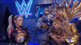 two women are standing next to each other on a stage in front of a wwe logo .