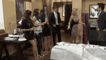 a group of people are standing in a room with a picture on the wall that says ' a ' on it