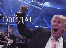 a man in a suit and tie is raising his fist in the air with a sign that says ' toiida ' on it