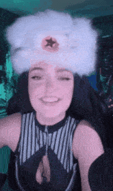 a woman wearing a white hat with a star on it is smiling and looking at the camera .