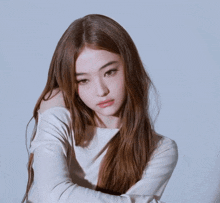 a woman with long brown hair is wearing a white shirt