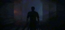 a silhouette of a person standing in a dark room with a knife in their hand .