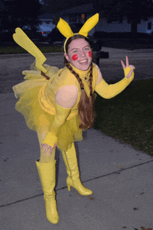 a woman in a pikachu costume stands on the sidewalk
