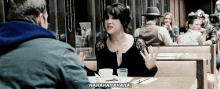 a man and a woman are sitting at a table in a diner laughing .