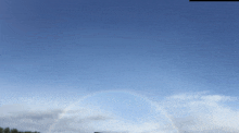 a clear blue sky with a rainbow in the middle