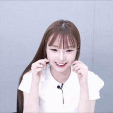 a girl wearing a white shirt and a black microphone