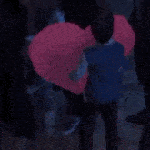 a blurry picture of a person standing in front of a pink light .