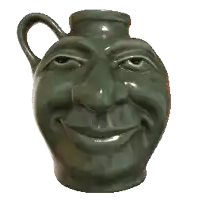 a green vase that looks like a smiling face