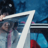 a woman is looking out of a car window with a ponytail