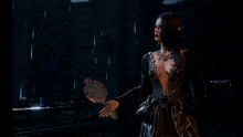 a woman in a black dress stands in the rain in front of a stained glass window