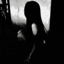 a black and white photo of a woman in a dark room