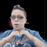 a man making a heart shape with his hands with the words tap to edit text below him
