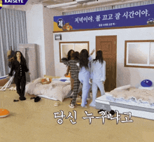 a group of women are standing in a room with a sign that says kaiseye