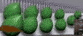 a bunch of green balls are sitting on top of a white surface .