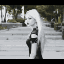 a woman with long white hair and red lipstick is wearing a black dress .