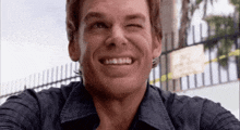 a close up of a man 's face with a fence in the background .