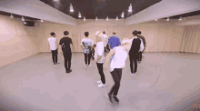 a group of young men are dancing in a dance studio with the letter p on the bottom left