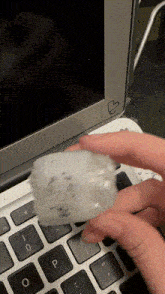 a person holding a piece of plastic over a keyboard