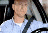 a man is driving a car with his eyes closed and his head resting on the steering wheel .