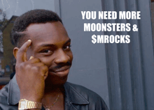 a man holds his finger to his forehead in front of a sign that says you need more moonsters & $ mrocks