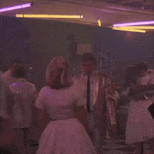 a group of people are dancing together in a dark room