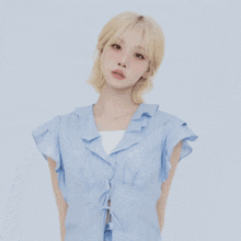 a woman with blonde hair is wearing a light blue shirt