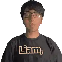a man wearing glasses and a black shirt with the word liam on it