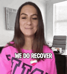 a woman wearing a pink shirt with the words we do recover on it