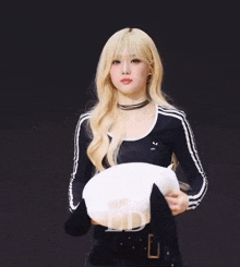 a woman with blonde hair is holding a white bowl with the letter ld written on it