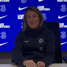 a woman wearing a blue nike jacket with the number 3 on the front