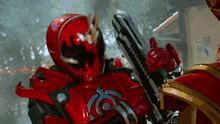 a man in a red helmet is holding a gun with the letter o on it