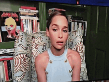 a woman is sitting in front of a bookshelf with a magazine titled mon on it