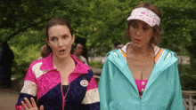 two women standing next to each other with one wearing a jacket with a gucci logo
