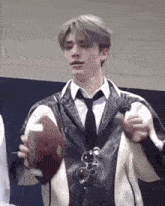 a young man in a suit and tie is holding a football in his hand .