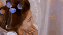 a woman with curlers in her hair is holding another woman 's hand .