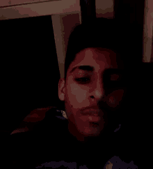 a blurry picture of a man 's face with a beard in a dark room
