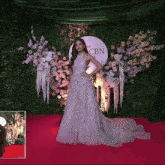 a woman in a white dress stands in front of a cbn sign