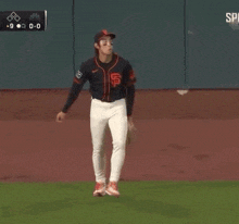 a baseball player wearing a san francisco giants uniform stands on the field