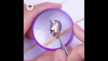 a person is painting a picture of a unicorn on a purple plate .