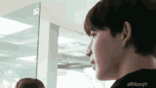 a close up of a man 's face looking at another man in a room .