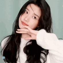 a woman with long black hair is making a peace sign with her hand