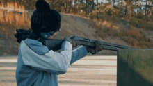a woman is holding a shotgun in front of a sign that says cryptv