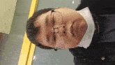 a man wearing glasses and a mask looks down