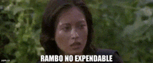 a man in a black tank top is standing in the woods with the words rambo no expendable above him
