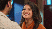 a man and a woman are smiling at each other and looking at each other .