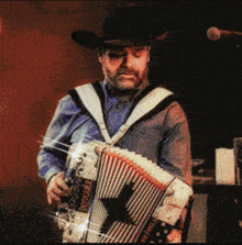 a man wearing a cowboy hat is playing an accordion that says nashville on it