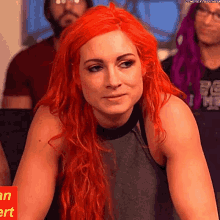 a woman with red hair is sitting in front of a crowd