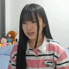 a girl wearing a pink and white striped shirt that says t-im