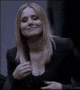 a woman in a black jacket is giving the middle finger .