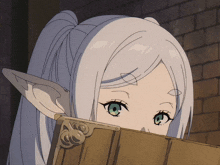 a girl with white hair and green eyes peeking over a book